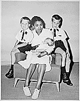 H0006-2. Clara Powell holds infant Steven Ford as Jack Ford and Michael Ford look on. June 1956.