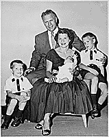 H0007-3. Mrs. Ford holds Steven Ford as Gerald R. Ford, Jr., Jack Ford, and Michael Ford look on. June 1956. 