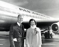 Gerald and Betty Ford pose for a photograph at an unidentified airport. Mrs. Ford was wearing a neck brace for pain. 1964.