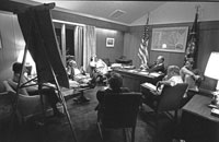 White House Chief of Staff Dick Cheney comments during a campaign strategy session at Camp David. (Counterclockwise from President Ford are his son Jack Ford, Counselor John Marsh, Robert M. Teeter of Market Opinion Research Corp., President Ford Committee Deputy Chairman for Political Organization Stuart Spencer, Cheney, and Counselor and speechwriter Robert Hartmann.) August 6, 1976. 