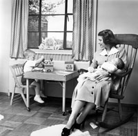 Betty holds second son Jack Ford while eldest son Michael plays a t a small table in their apartment at 1521 Mount Eagle Place, Alexandria, Virginia. 1952. 