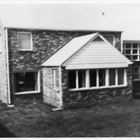 A black and white exterior picture of the Ford family house is shown from the rear