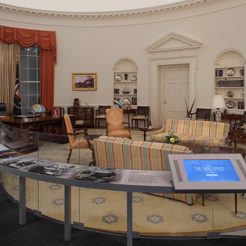 A look into the Oval Office exhibit at the museum showcasing the desk, chairs, sofas and tables arranged as they were in the White House.