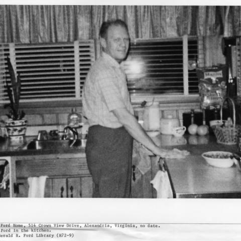 A black and white picture of Gerald. R. Ford standing in the kitchen at 514 Crown View Drive, Alexandria, Virginia