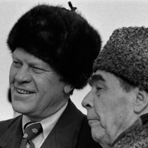 A2102-07A - President Ford dons a Russian wool cap upon his arrival in Soviet Union, shown here with Soviet General Secretary Leonid Brezhnev at Vozdvizhenka Airport, Vladivostok, USSR.  November 23, 1974.