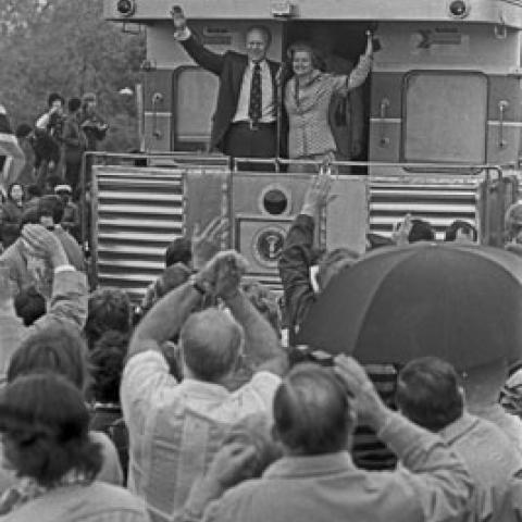 A9804-26A. President and Mrs. Ford wave from the rear of the train during their primary campaign whistle-stop tour of Michigan.  Durand, Michigan.  May 15, 1976.