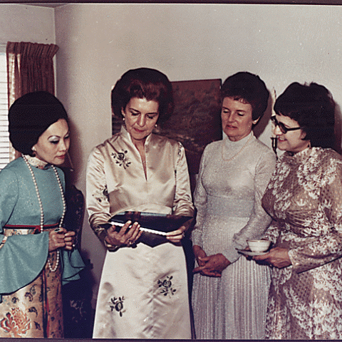 H0001-2. Betty Ford and three unidentified women looking at photographs. 1972.