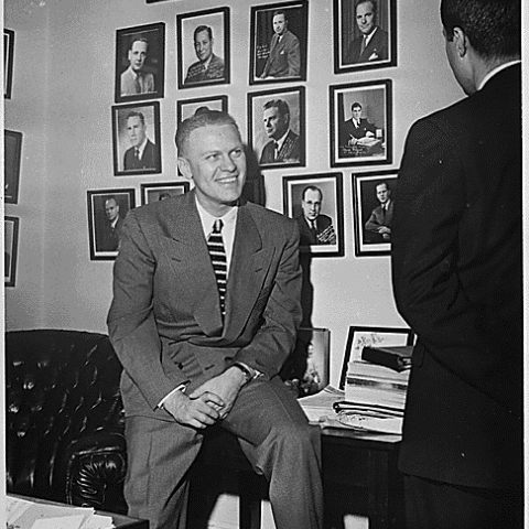 H0011-3. Representative Gerald R. Ford, Jr., talks to an unidentified visitor in his House Office. 1950.