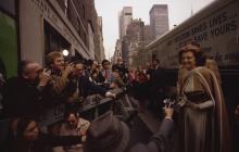 Betty Ford greets reporters standing in front of a bus that says "Early detection saves lives...it may save yours"