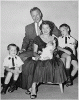 H0007-3. Mrs. Ford holds Steven Ford as Gerald R. Ford, Jr., Jack Ford, and Michael Ford look on. June 1956.