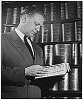 H0012-2. Representative Gerald R. Ford, Jr., pages through a bound copy of 1952 Congressional hearings. 1953.