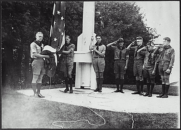 H0024-2. Gerald R. Ford, Jr. holds the flag as he and his fellow members of the Eagle Scout Guard of Honor prepare to raise the colors over Fort Mackinac at Mackinac Island State Park, MI. The troop served as guides during the summer months. August 1929.