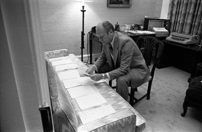 A0149-19. President Ford examines documents related to potential Vice Presidential nominees in the office of his Counsellor, Robert T. Hartmann.  August 15, 1974.
