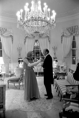 A1222-26 - Susan Ford adjusts President Ford’s tuxedo in the Yellow Oval Room of the Residence prior to a White House reception for diplomats. October 5, 1974. Susan served as the official hostess while her mother recovered from breast cancer surgery.