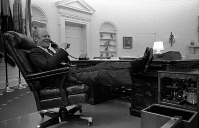 A1285-27. President Ford takes a call after delivering his Address on the Economy to a Joint Session of Congress.  Oval Office.  October 8, 1974. 