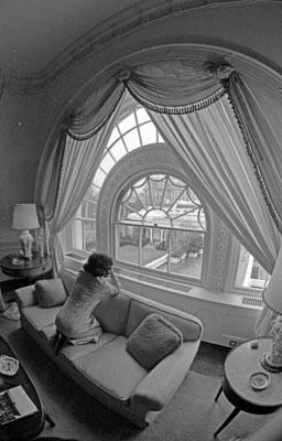 A2852-13. First Lady Betty Ford gazes toward the Oval Office from a window in the White House residence.  January 20, 1975.