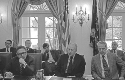 A4283-25A. President Ford, Secretary of State Henry A. Kissinger (left) and Secretary of Defense James R. Schlesinger (right) at a meeting with bipartisan congressional leaders to discuss the situation in South Vietnam. April 29, 1975.