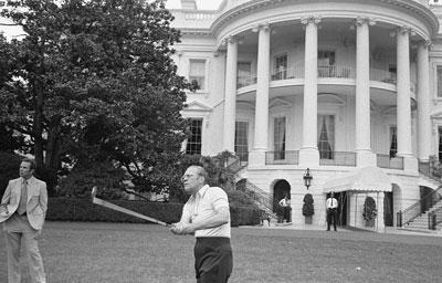 A4474-25. President Ford practices golf on the South Lawn of the White House under the watchful eye of the Secret Service.  May 9, 1975. 