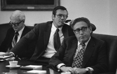 A4530-11. Philip Buchen, Counsel to the President, Chief of Staff Donald H. Rumsfeld and Secretary of State Henry A. Kissinger attend to a map presentation by Acting Chairman of the Joint Chiefs of Staff David C. Jones (USAF) on the status of the rescue operation to gain the release of the crew of the S.S. Mayaguez. May 14, 1975.