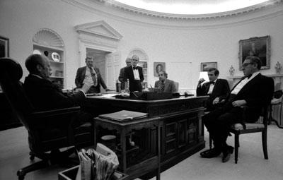 A4554-10. President Ford and senior staff members stay late into the night to learn of the recapture of the S.S. Mayaguez and its crew.  May 14, 1975.