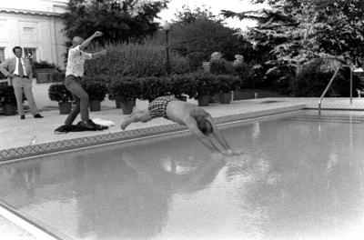 A5325-08 - Susan Ford assists her father as he dives into the new White House. July 1, 1975.