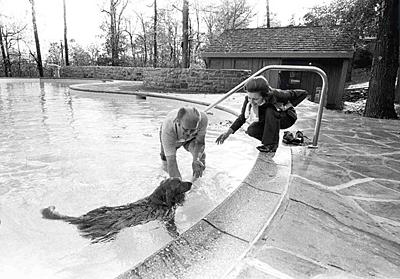 A1634-01. President and Mrs. Ford with their dog Liberty at the Camp David swimming pool. October 26, 1974