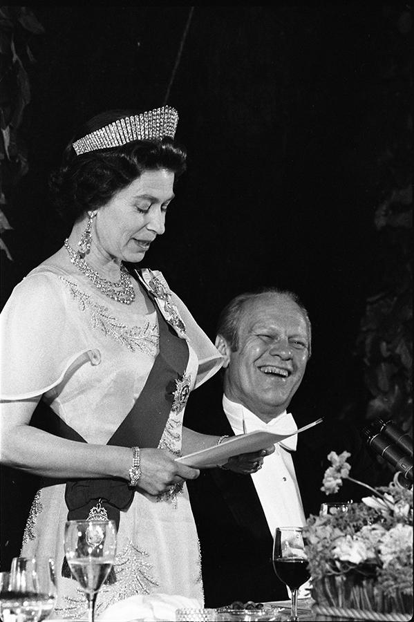 B0593-16. President Ford laughing as Queen Elizabeth II delivers remarks at a state dinner honoring Her Majesty. July 7, 1976.