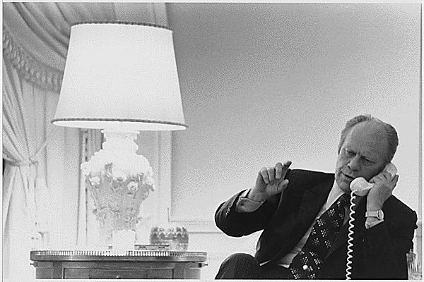 A4232-23A. President Gerald R. Ford takes a final phone call from Secretary of State Henry A. Kissinger, bringing him up to date on the situation in Vietnam, following a nighttime meeting in the West Sitting Room with the Secretary and Deputy National Security Adviser Brent Scowcroft, April 28, 1975.