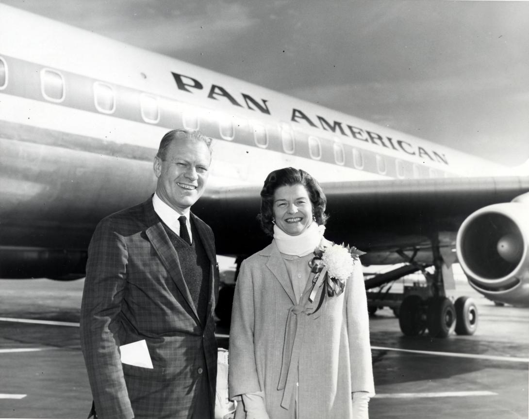 AV82-18-1180. Congressman Gerald Ford and wife Betty pose for a photograph at an unidentified airport. Mrs. Ford was wearing a neck brace for pain. 1964.