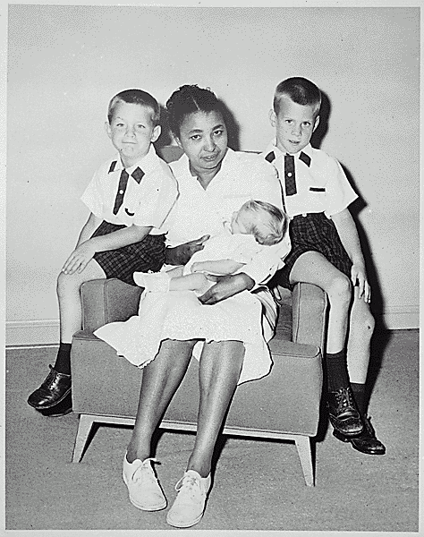 H0006-2. Clara Powell holds infant Steven Ford as Jack Ford and Michael Ford look on. June 1956.