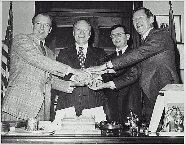 H0011-2. Representative Gerald R. Ford poses with his half-brothers Dick, Jim, and Tom Ford in the Minority Leader's Office. 1970.