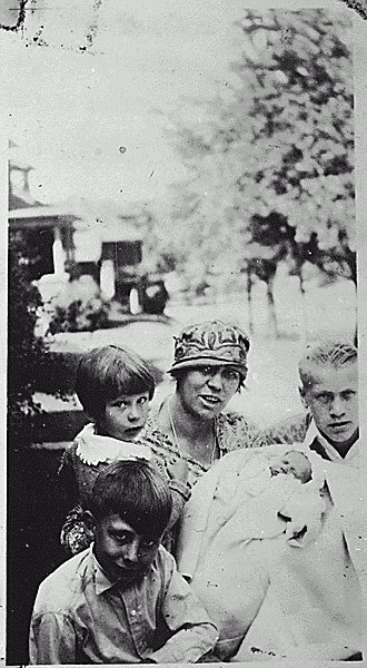 H0026-3. Gerald R. Ford, Jr. with his mother Dorothy Gardner Ford and half-brothers Tom, Dick and Jim Ford pose in front of their home. September 1927.
