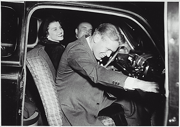 H0038-1. Gerald R. Ford, Jr., and Betty Ford sit in the front seat of an automobile driven by Jack Beckwith following their wedding reception. October 15, 1948.