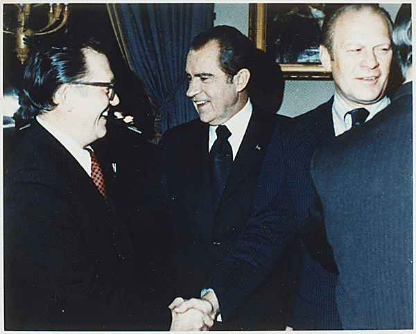 H0050. Senator Robert Griffin (MI) shakes hands with President Richard M. Nixon while Vice Presidential nominee Gerald R. Ford chats with a well-wisher at a reception in the Blue Room following Nixon's announcement of Ford as his choice to succeed Spiro T. Agnew. October 13, 1973.