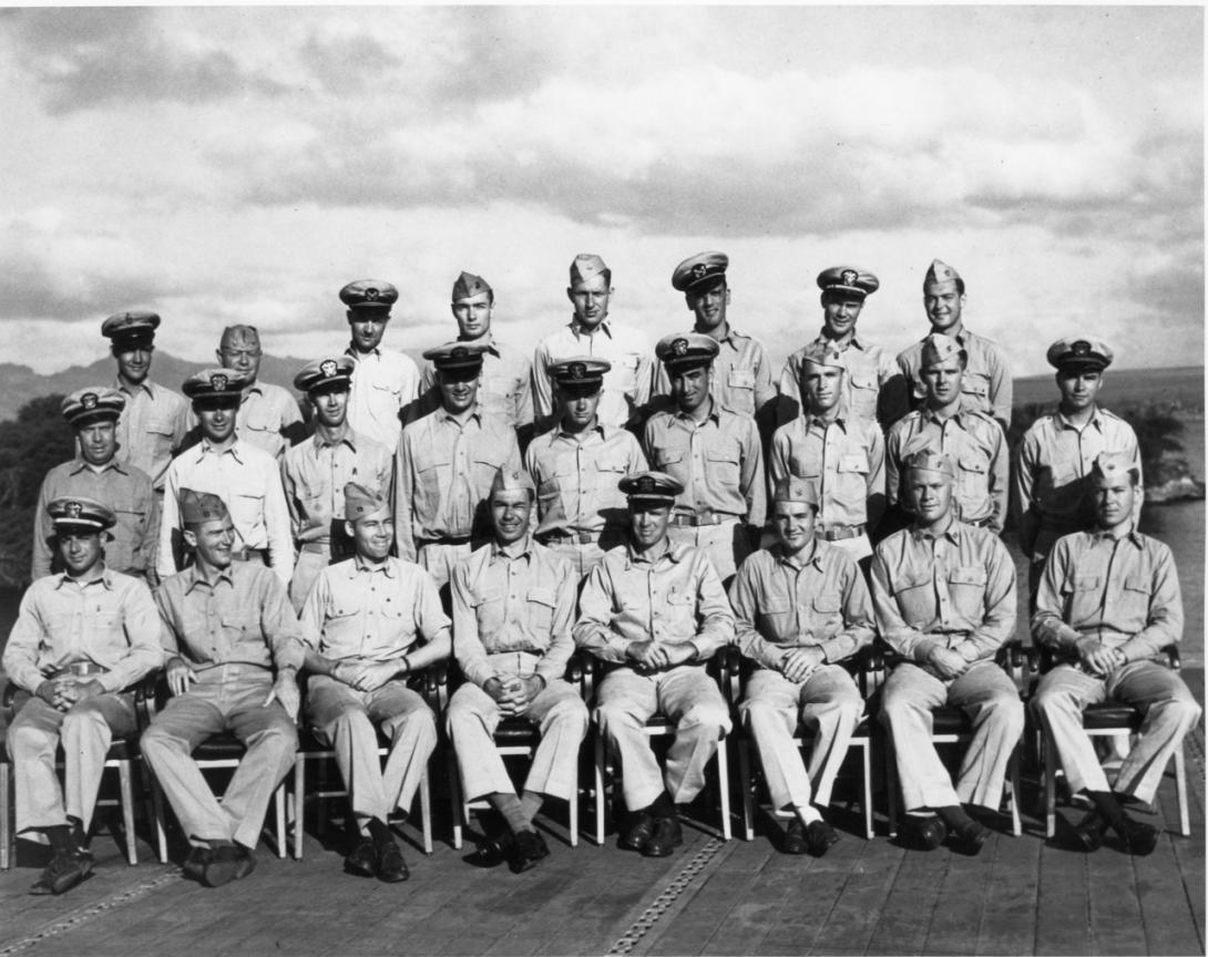 A group of men are sitting together in formation. They are from the USS Monterey. 